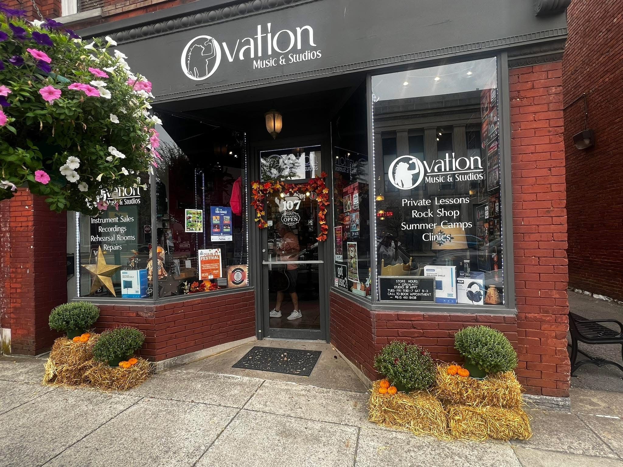 Storefront of Ovation Music & Studios in Gallatin, TN, decorated with fall flowers.