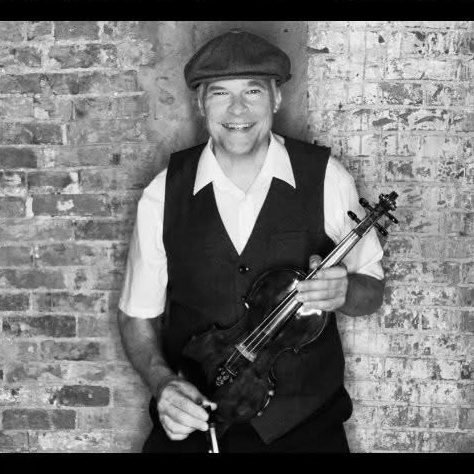 Portrait of Ovation instructor Travis Wetzel holding a violin.